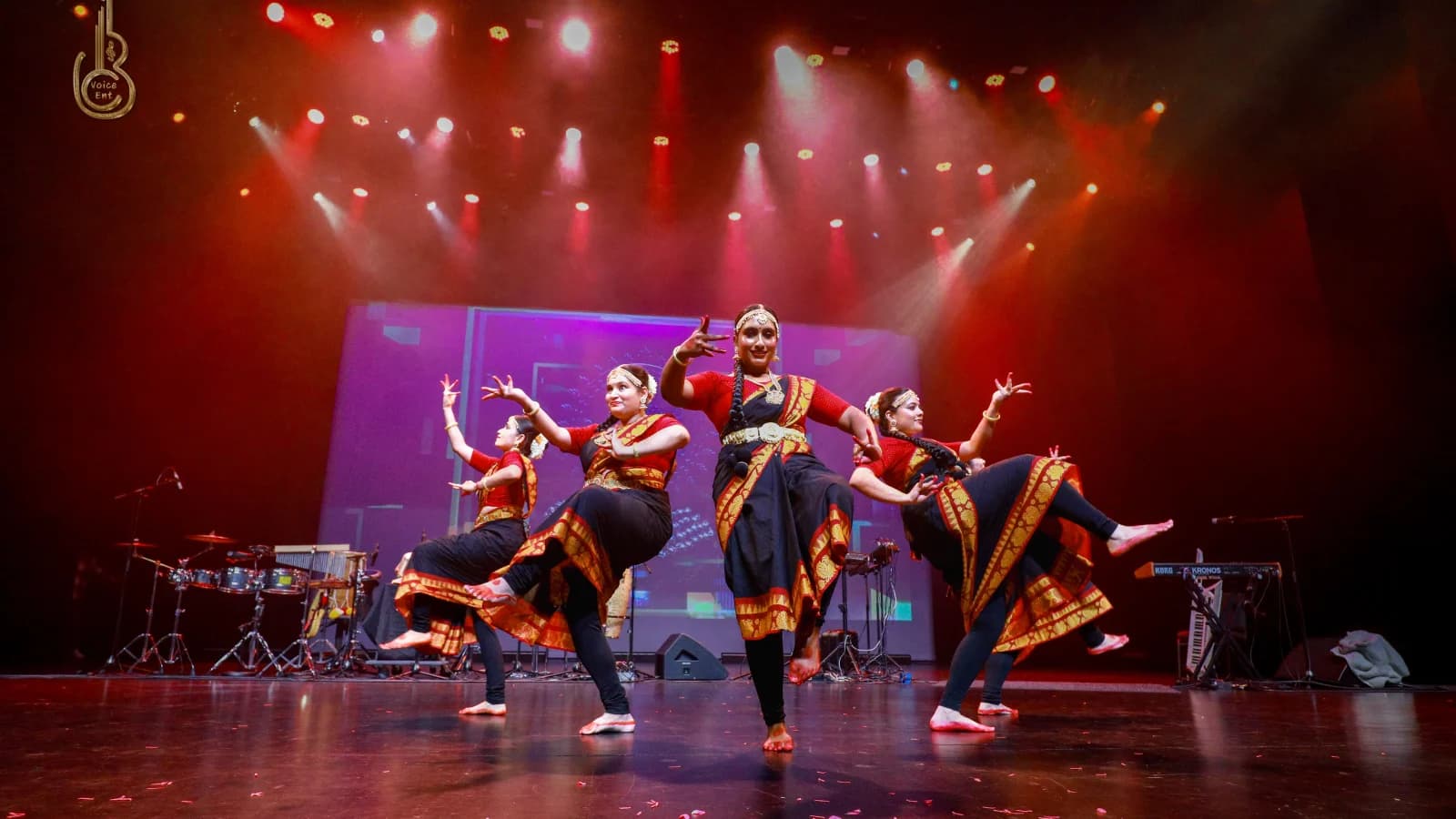 Dancers performing on stage under colorful lights at a BC Voice event