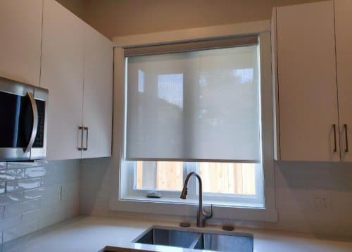 Roller shade installed over a kitchen window in a DBS Blinds project